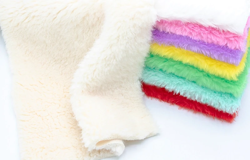 Macro shot of soft white faux rabbit fur fabric highlighting the dense pile and silky finish.